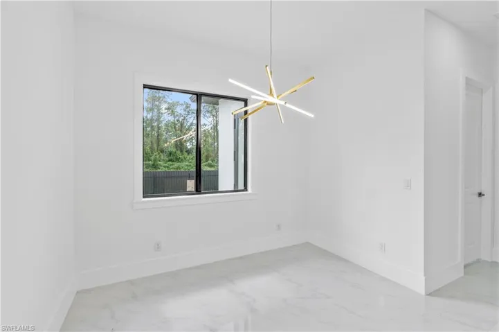 Unfurnished room featuring a chandelier