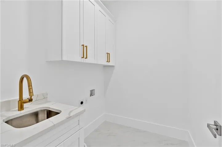 Laundry area featuring washer hookup, cabinets, sink, and hookup for an electric dryer