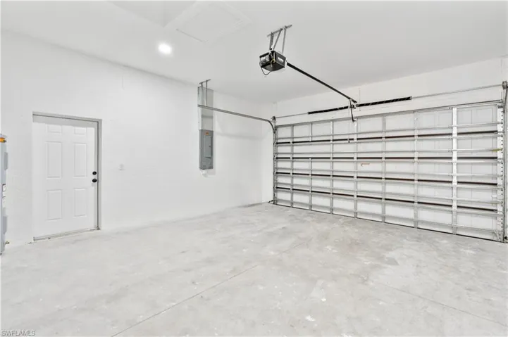 Garage featuring electric panel and a garage door opener