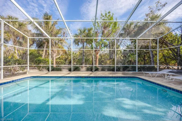 View of swimming pool featuring glass enclosure