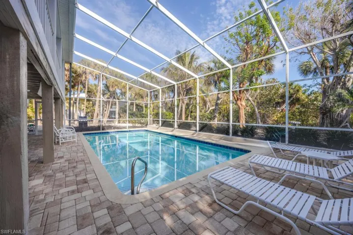 View of swimming pool with a lanai and a patio