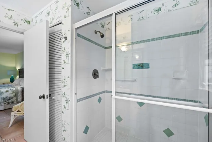 Bathroom featuring tile patterned floors and a shower with door