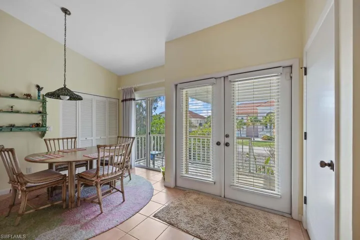 Dining area with french doors, lofted ceiling, and light tile patterned flooring