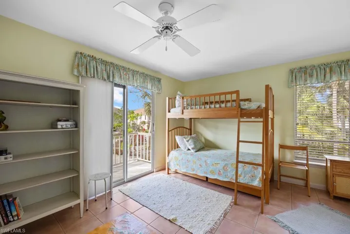 Tiled bedroom with access to outside and ceiling fan