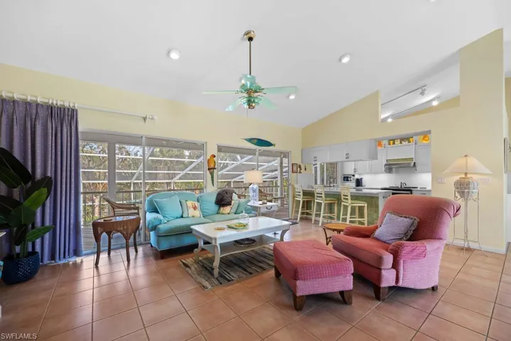 Tiled living room with vaulted ceiling and ceiling fan