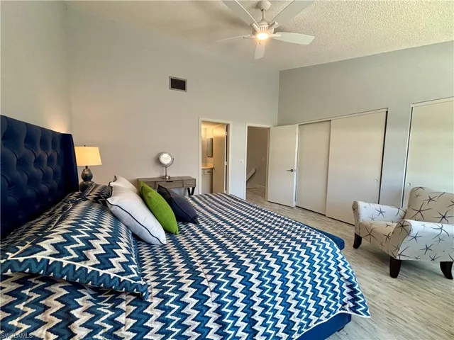 Bedroom featuring multiple closets, a ceiling fan, and high vaulted ceiling