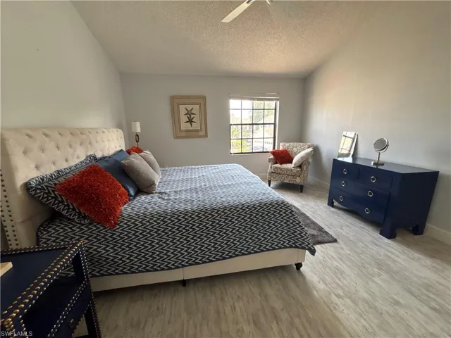 Bedroom with wood finished floors and a textured ceiling