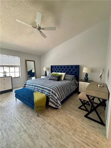 Bedroom featuring wood finished floors, a textured ceiling, and a ceiling fan