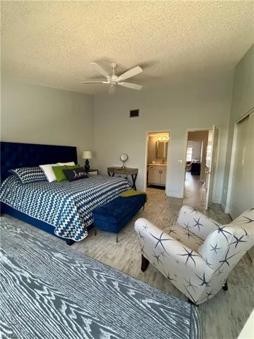 Bedroom featuring a textured ceiling, wood finished floors, and ceiling fan