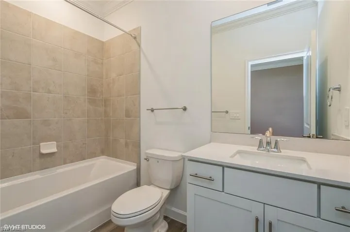 Bathroom featuring vanity, shower / washtub combination, and ornamental molding