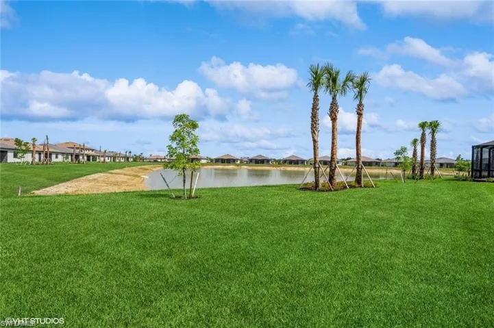View of grassy yard featuring a residential view and a water view