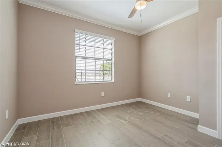 Spare room featuring ornamental molding, wood finish floors, and ceiling fan