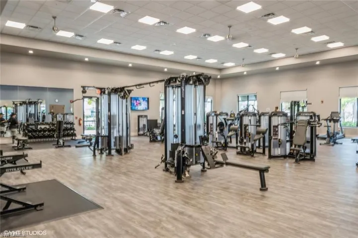 Exercise room with a paneled ceiling and a towering ceiling