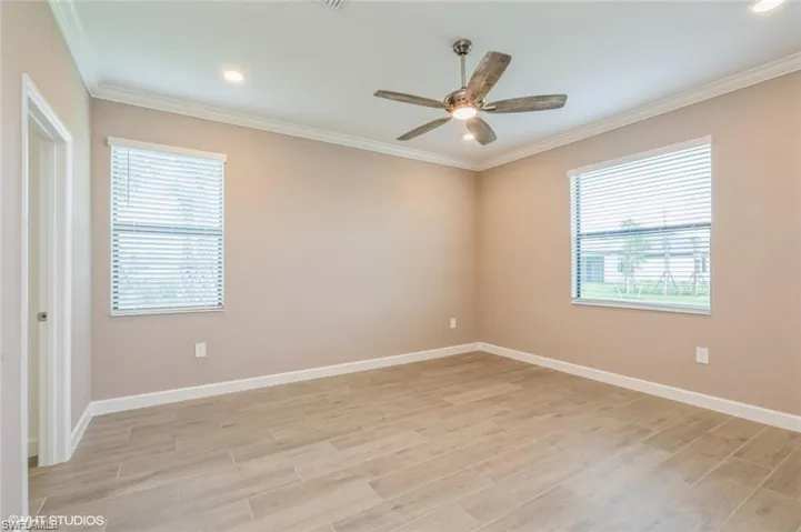 Unfurnished room with ornamental molding, light wood-style flooring, a ceiling fan, and recessed lighting