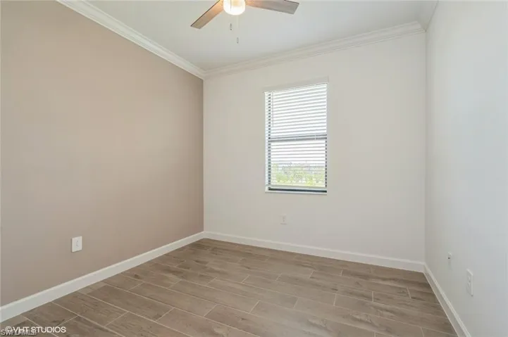 Unfurnished room featuring wood tiled floors and ornamental molding