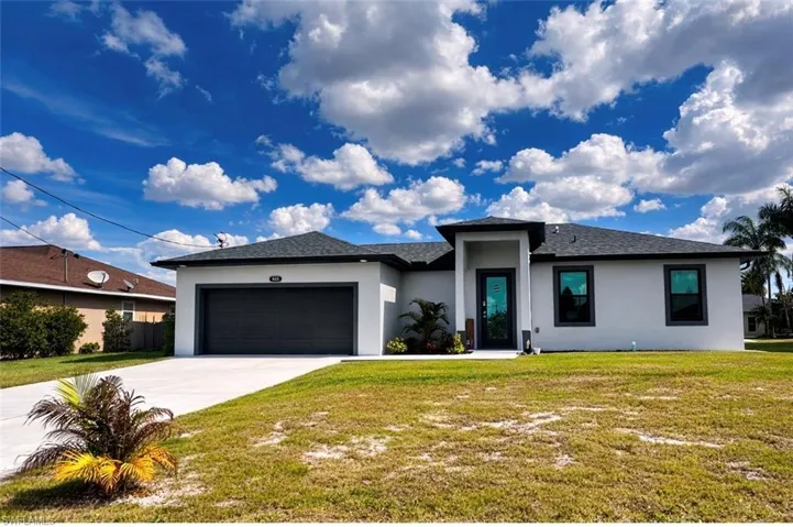 View of front of house featuring a front yard, an attached garage, stucco siding, driveway, and a shingled roof