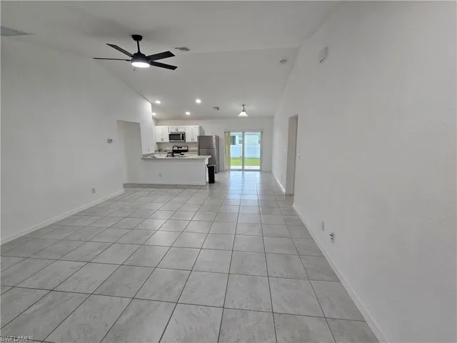 Open-concept living space with vaulted ceilings, contemporary ceiling fan, and tile flooring