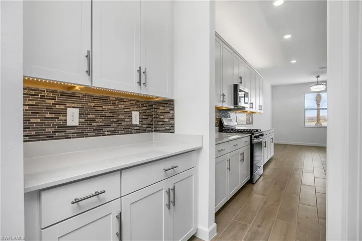 You'll love the coffee bar/butler pantry walk through area adjacent to the walk-in pantry with custom shelving.