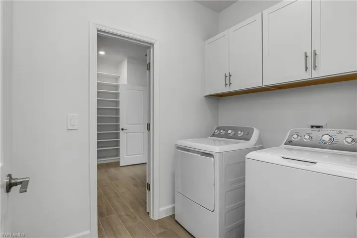 Laundry room is accessible from the owner closet as well as from the common area and includes additional cabinetry above washer/dryer for extra storage.