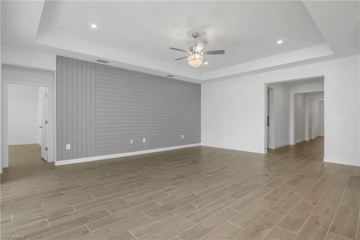 Great room with recessed lighting, feature wall, impact glass sliders providing lots of natural light.