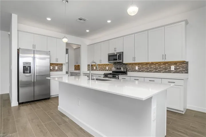 Oversized island and floor plan with open kitchen/dining/great room make this home perfect for entertaining. Note the over and under cabinet lighting!