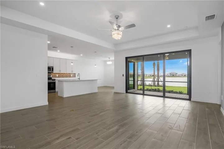 Open Great room, dining, kitchen with glass sliders to your covered outdoor lanai with water view.