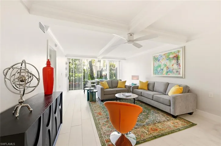 Living area featuring crown molding and beamed ceiling