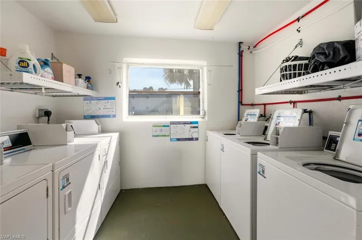 Community laundry room with washing machine and dryer
