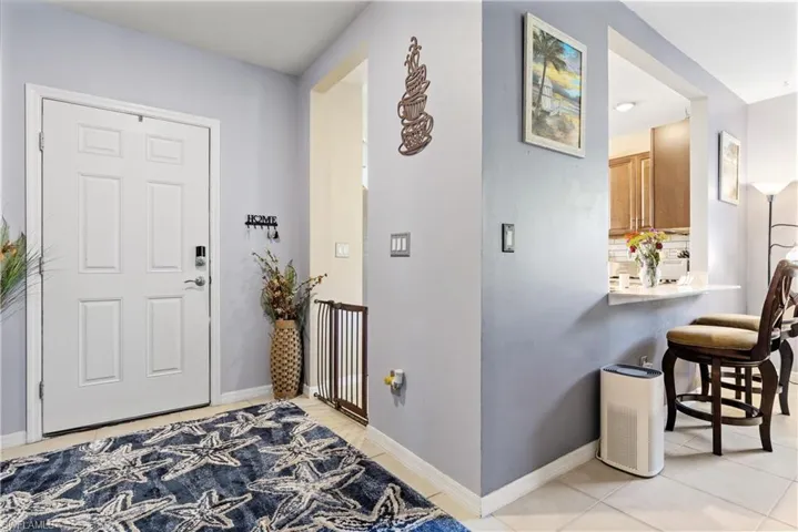 Entrance foyer with light tile patterned floors and baseboards
