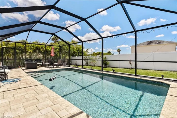 View of swimming pool with a patio area, a fenced backyard, and a lanai
