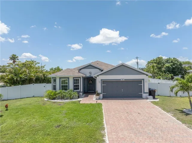 Ranch-style home featuring a gate, an attached garage, decorative driveway, and stucco siding
