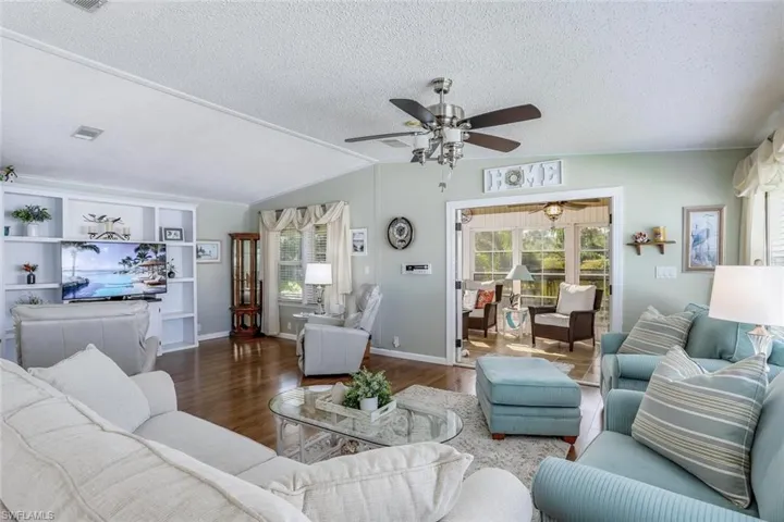 Wood-look flooring throughout the main living area and vaulted ceilings, Living Room opens to Florida Room.