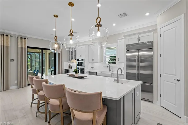 Kitchen with visible vents, crown molding, a center island with sink, stainless steel appliances, and a sink