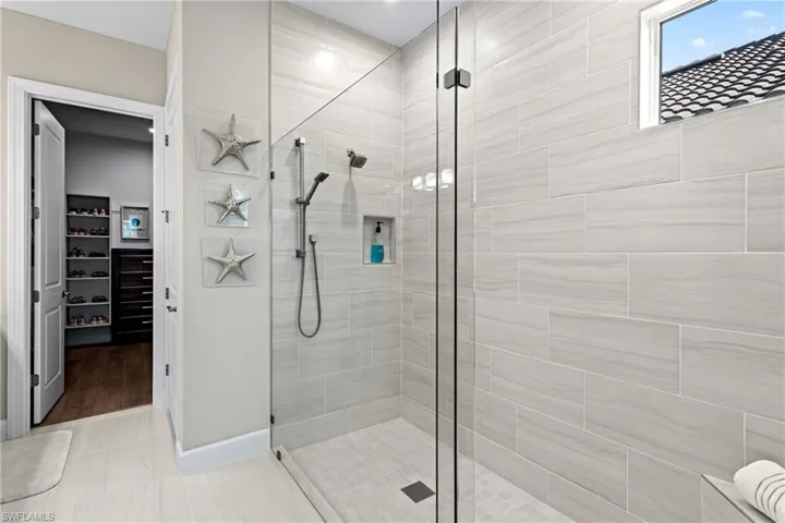 Full bath featuring a walk in closet and a shower stall