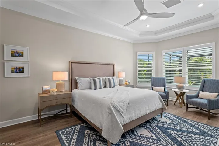 Bedroom featuring visible vents, ornamental molding, baseboards, and wood finished floors