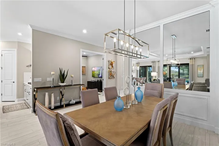 Dining area with ornamental molding, wood finished floors, recessed lighting, baseboards, and a chandelier