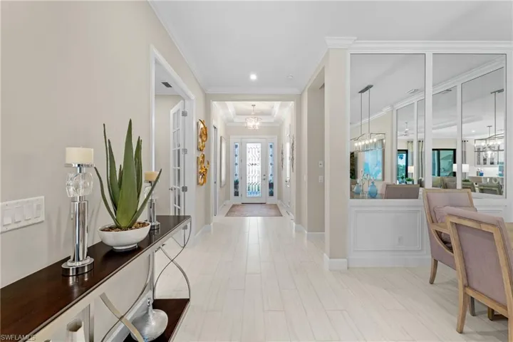 Foyer entrance with baseboards, an inviting chandelier, and ornamental molding
