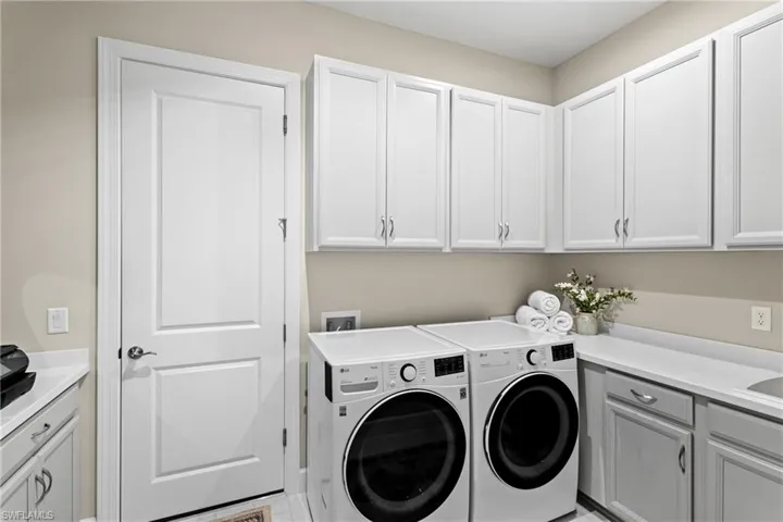Laundry area featuring cabinet space and washing machine and dryer