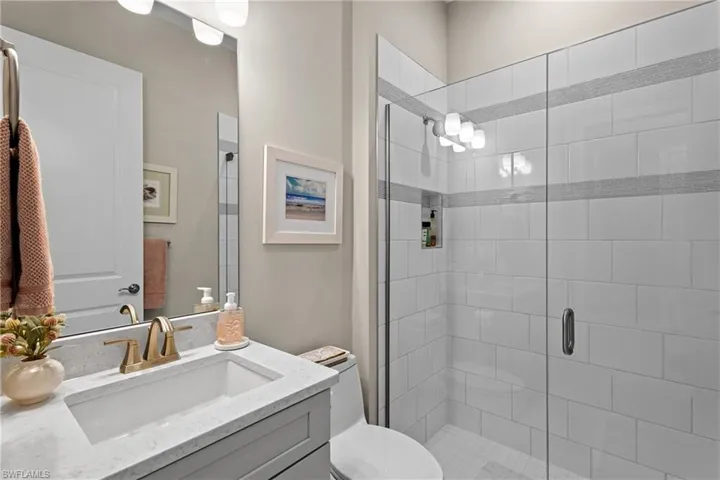 Full bathroom with a stall shower, toilet, and vanity