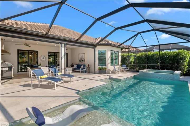 View of swimming pool featuring glass enclosure, a pool with connected hot tub, ceiling fan, outdoor lounge area, and a patio area