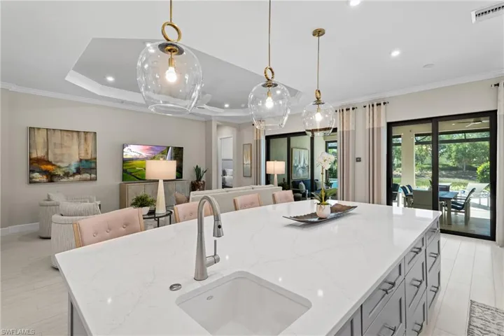 Kitchen featuring open floor plan, ornamental molding, visible vents, and a sink