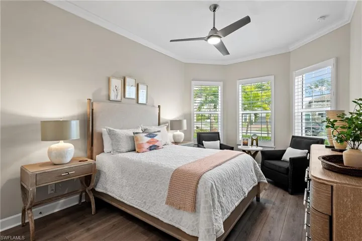 Bedroom with baseboards, a ceiling fan, crown molding, and hardwood / wood-style flooring