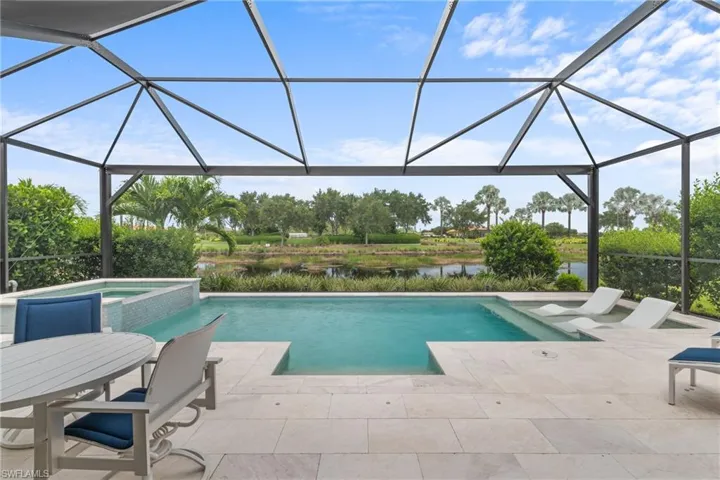 View of swimming pool with a patio, a water view, a pool with connected hot tub, and a lanai