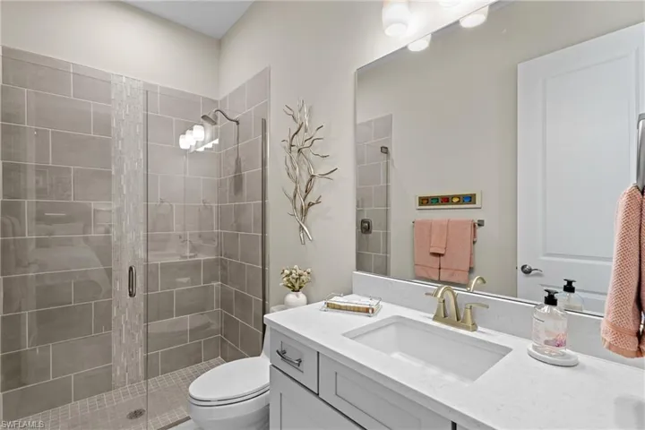 Full bathroom featuring a shower stall, toilet, and vanity