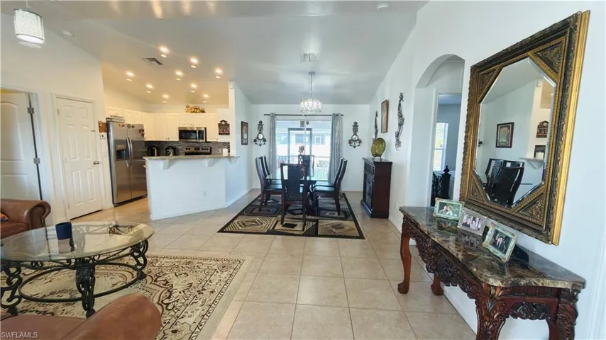 Dining area featuring suspended lighting, light tile patterned flooring, and lofted ceiling