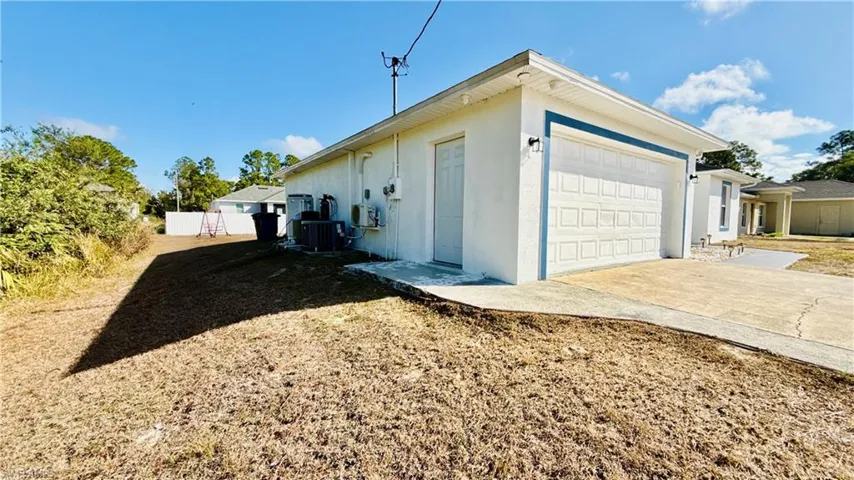 View of side of home with an attached garage, and side door.