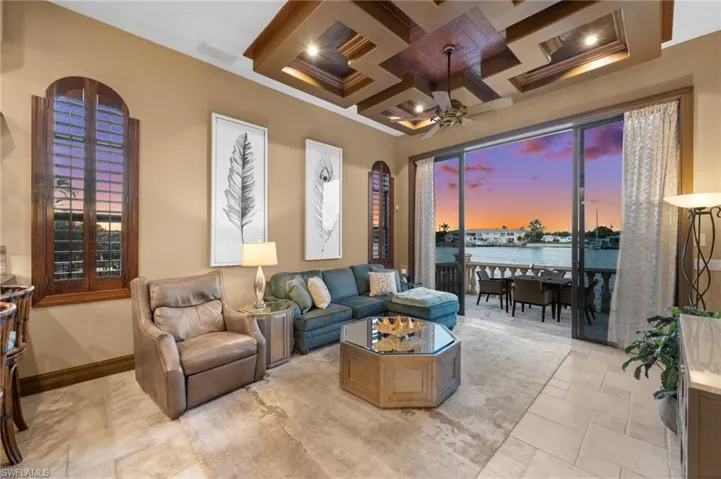 Living room with a water view, coffered ceiling, beamed ceiling, and ceiling fan