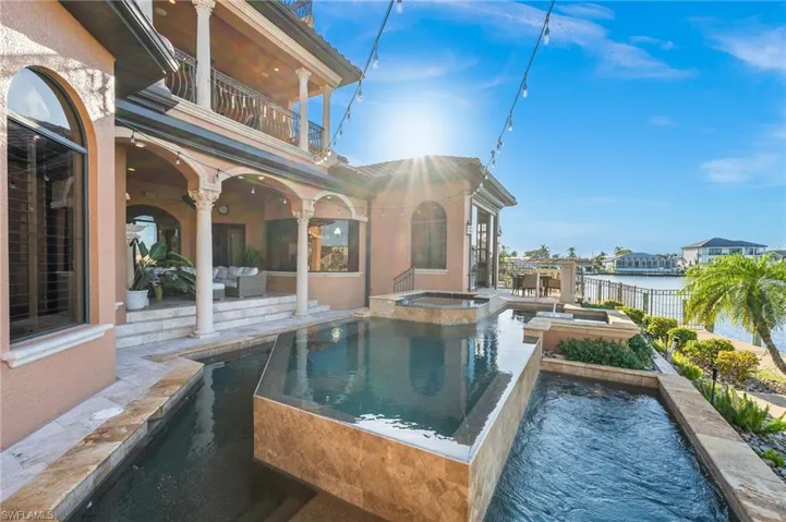 View of swimming pool with a patio, an in ground hot tub, an outdoor hangout area, and a water view
