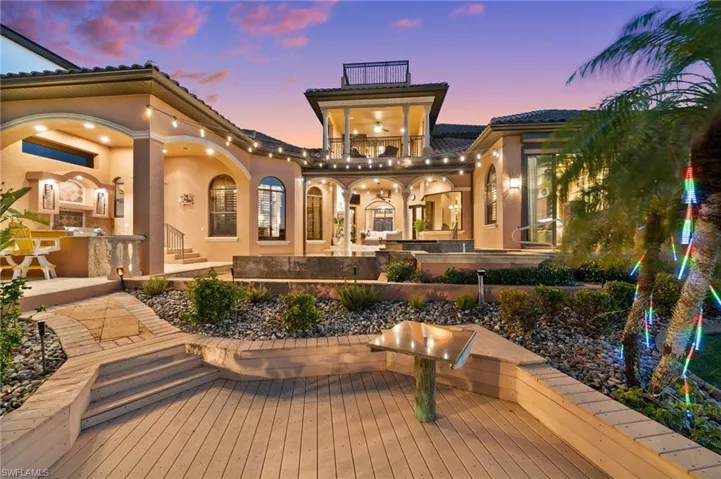 Back house at dusk featuring a balcony