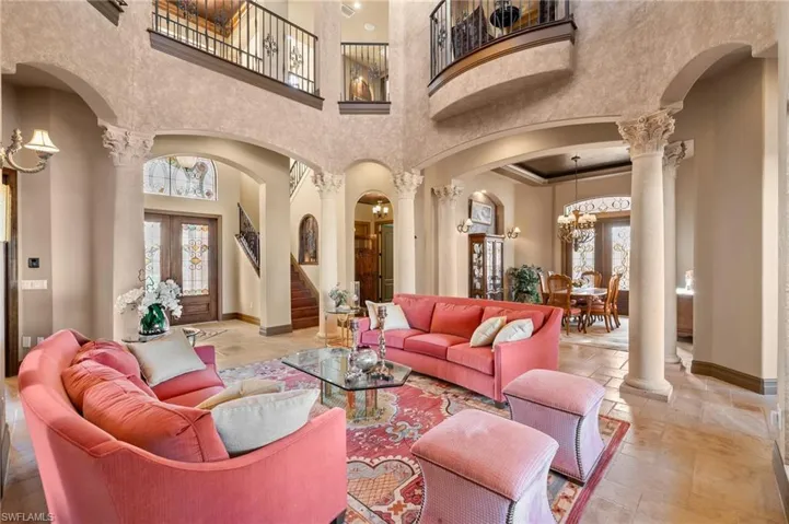 Living room featuring a chandelier, a high ceiling, and decorative columns